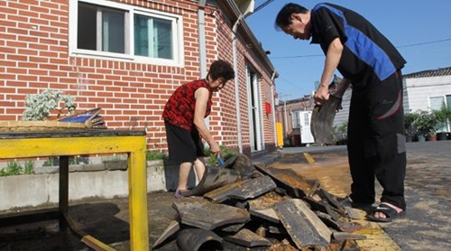 １３日慶尚北道慶州市皇南洞（キョンサブクド・キョンジュシ・ファンナムドン）の住宅で、住民たちが前日に発生した地震の影響で屋根から落ちたり破損したりした瓦を整理している。