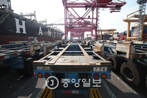 物流大乱が依然として進行形の中、先月２３日に釜山新港ターミナルに停泊した韓進海運の船舶の横に空のトレーラーが列を作っている。