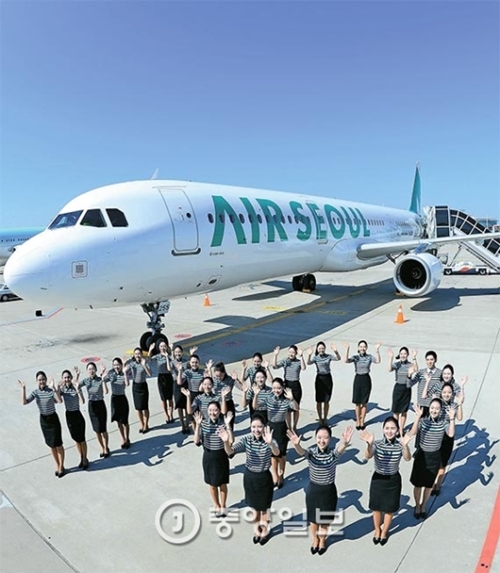 ５日、川国際空港係留場で開かれた航空機導入式で格安航空会社「エアソウル」の乗務員が記念撮影に臨んでいる。