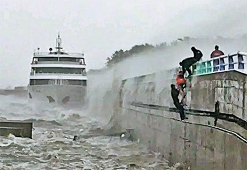 ５日、全羅南道麗水市梧桐島の防波堤で海にさらわれた乗組員を海洋警察が救助している。（写真提供＝麗水海洋警備安全署）