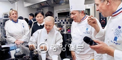 ル・コルドン・ブルーでソンジェ僧侶（右から３人目）が韓国寺刹料理特講をしている。えりに三色のカラーを巻いた国家公認シェフであるブロア・オグルルト校長（右から２人目）とエリック・ブリファール教授が２０年熟成した韓国の醤油を味わっている。