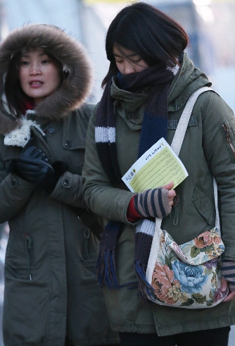 防寒のためマフラーや手袋をしている市民。