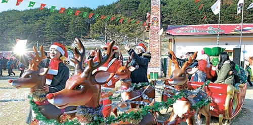 慶尚北道奉化郡小川面の汾川駅で２０１６冬サンタの村開場式が１７日に開かれた。観光客が赤鼻のトナカイのソリのオブジェを背景に写真を撮っている。