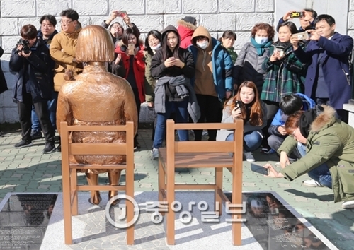 釜山日本領事館前に設置された平和の少女像を市民が撮影している。