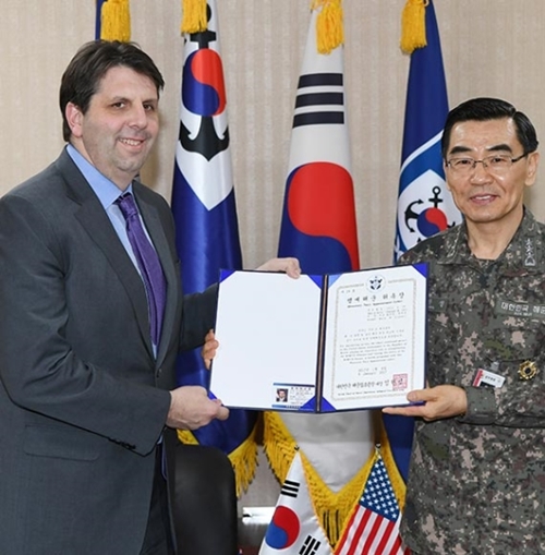 ９日、マーク・リッパート駐韓米国大使（左）がチョン・ジンソプ海軍作戦司令官（右）から「名誉海軍」委嘱状を手渡されている。（写真＝韓国海軍）