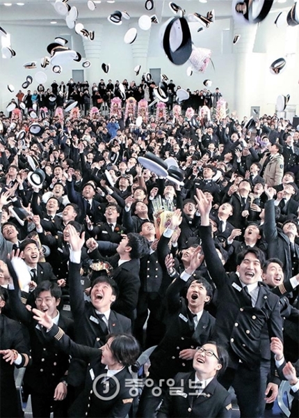 ２３日、釜山韓国海洋大学体育館で行われた海事大学卒業式で卒業生が帽子を投げている。