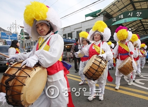 写真＝正月テボルム（小正月、２月１１日）を４日後に控えた７日、釜山市中区の国際市場で韓国自由総連盟の中区支会のメンバーが厄除けの地神踏みをしながら市内を練り歩いている。