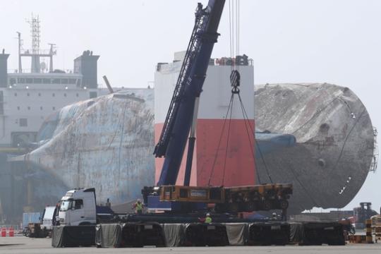 セウォル号の陸上据え置きのための作業が進められている中、７日午後に海洋水産部が木浦新港埠頭に追加投入したモジュールトランスポーターを関係者らが下ろしている。
