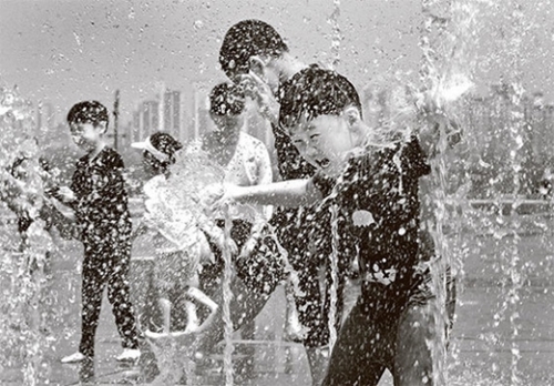 ３０日、ソウル汝矣島の漢江公園ムルビッ広場噴水台で子どもたちが水遊びをしている。