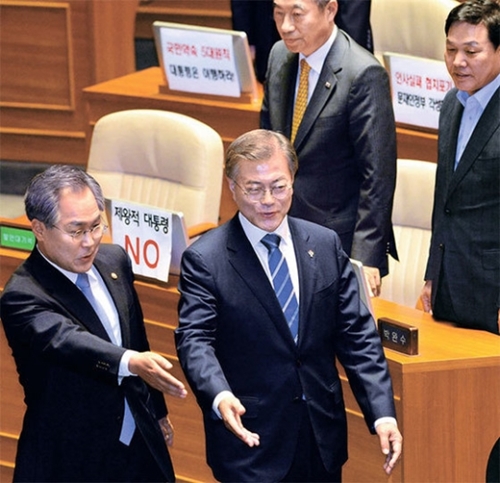 文在寅大統領が１２日午後、国会で補正予算案に関する施政演説を行った。文大統領は演説後、自由韓国党の議員らとあいさつを交わした。この日、韓国党の議員らは自分の席のモニターに「帝王的大統領ＮＯ」などと書かれた紙を貼って抗議の意を表示した。