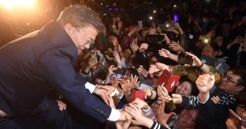 文在寅大統領が先月９日の当選直後、世宗路小公園で支持者と握手を交わしている。（中央フォト）