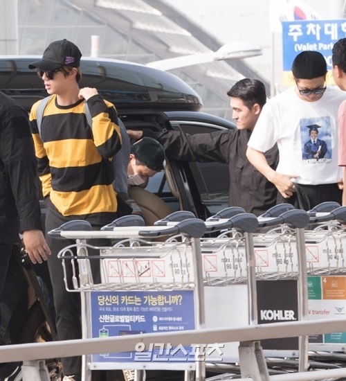 ２８日、仁川国際空港に到着したボーイズグループ防弾少年団。黄と黒の縞模様のシャツを来たメンバーのジンが遠くを見つめている。