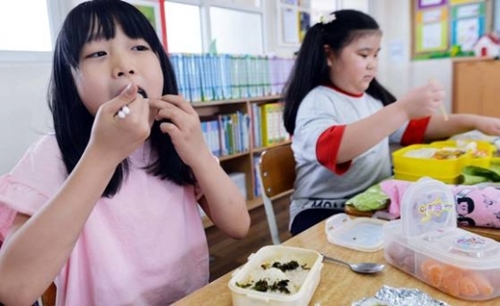大田のある小学校児童は教室で弁当を食べた。
