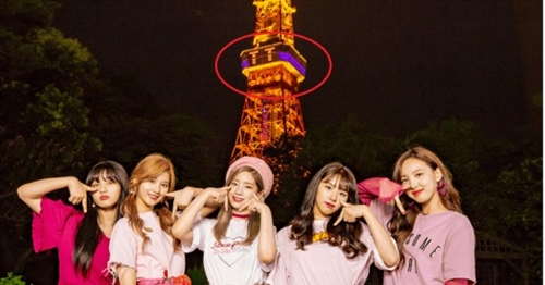 東京タワーの電光掲示板に表示された「ＴＴ」を背景に記念写真を撮影するＴＷＩＣＥ（写真＝ＴＷＩＣＥ日本公式サイト）
