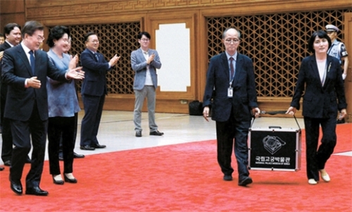２日、３泊５日の訪米日程を終えて韓国に戻ってきた文在寅大統領が、到着したソウル空港で、国立古宮博物館のキム・ヨンス館長（右）と学芸研究家のソ・ジュン氏が御宝を運ぶ様子を見守っている。