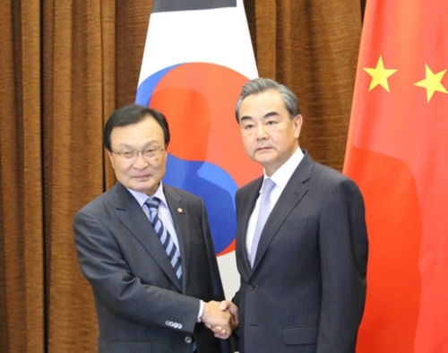 ことし５月１８日、文在寅大統領特使として中国を訪問した李海チャン議員（左）が中国外交部庁舎で王毅中国外交部長（右）と会って握手をしている。