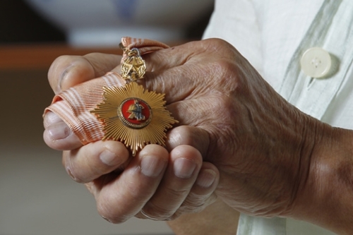 イ・イヌさんが６・２５戦争参戦で受けた忠武武功勲章を手に固く握っている。