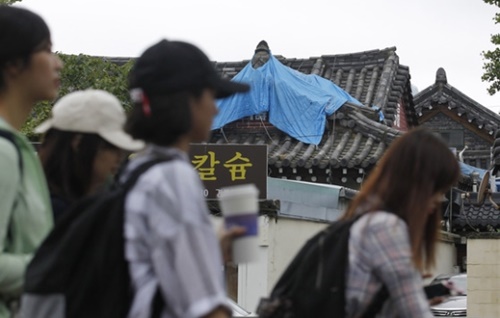 「慶州９・１２地震」発生１年を一日前に控えた１１日、慶北慶州市沙亭洞のある住宅が地震の被害でつぶれたまま、１年が過ぎても放置されている。外国人観光客がつぶれた韓国式家屋の前を通っている。