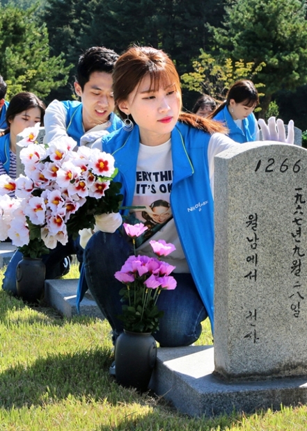 ２０日、国立ソウル顕忠院２６番墓地で墓碑を磨いている農協中央会の役職員と大学生広報大使。