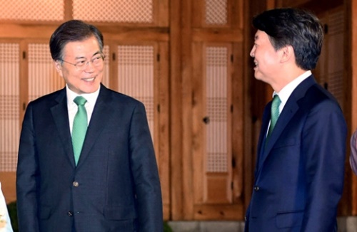 ともに緑色のネクタイをした文在寅（ムン・ジェイン）大統領（左）と安哲秀（アン・チョルス）代表が２７日、青瓦台で開かれた与野党４党代表会合で対話している。
