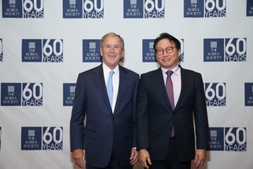 崔泰源ＳＫ会長（右）が米国ニューヨークのプラザホテルで開かれた「コリアソサエティー（ＴＨＥ　ＫＯＲＥＡ　ＳＯＣＩＥＴＹ）」創立６０周年記念行事に参加してブッシュ元大統領と記念撮影に臨んでいる。（写真提供＝ＳＫ）