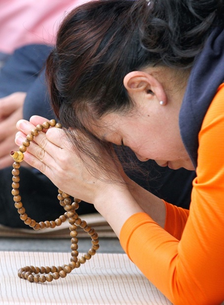 １５日午前、慶尚北道慶山市の八公山カッパウィを訪れた２０１８年度大学修学能力試験の受験生の母親が祈りを捧げている。