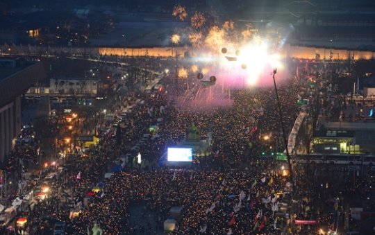 ３月１１日午後、ソウル光化門広場で開かれた弾劾歓迎ろうそく集会で参加者が弾劾認容決定を祝う花火を打ち上げている。（写真＝中央フォト）