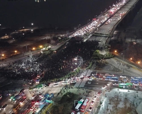 ２８日午後、韓国の全国建設労組組合員がソウル汝矣島国民銀行前で集会を終えた後、青瓦台に向かって行進する間、麻浦大橋南端を占拠してデモを行っている。（写真＝読者提供）