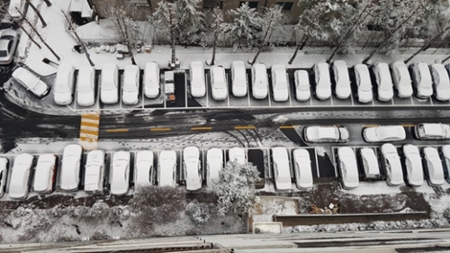１０日午前、ソウル盤浦（バンポ）のあるマンションの駐車場の様子。夜中に降った雪が車の上に積もっている。韓国気象庁は、１１日から当面の間は平年より気温が低くなると予報している。
