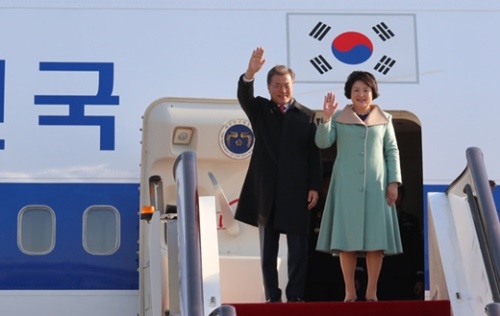 文在寅大統領夫妻が１３日、中国北京首都国際空港に到着し、飛行機から降りる前に挨拶をしている。（写真＝青瓦台写真記者団