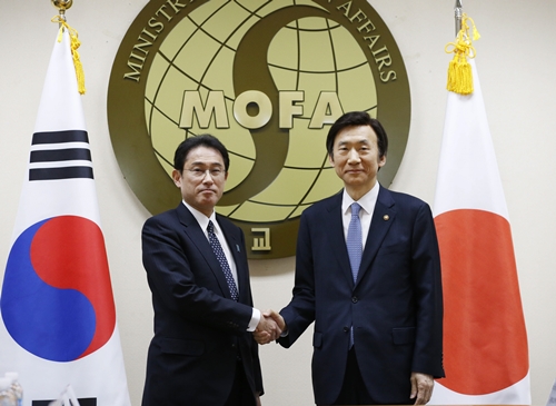 ２０１５年１２月２８日、ソウル外交部庁舎で韓国の尹炳世（ユン・ビョンセ）外交部長官（右）と日本の岸田文雄外相が慰安婦問題の解決策をさぐる会談に先立ち、握手をしている。