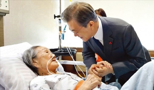 文在寅大統領が４日、ソウル新村セブランス病院を訪問して入院中である旧日本軍慰安婦被害者の金福童さんの手を握っている。（写真＝青瓦台）