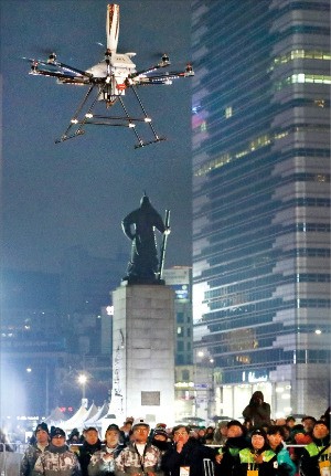 韓国通信大手のＫＴは今月１３日、ソウル光化門広場で５Ｇドローンを使って平昌冬季五輪聖火を２００メートルほど運んだ。（写真提供＝ＫＴ）
