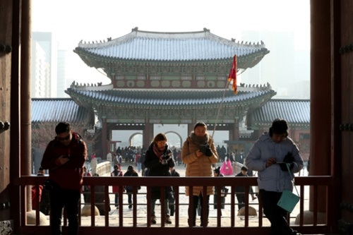 ２０１７年１２月２１日午後、ソウル景福宮（キョンボックン）を訪問した中国人団体観光客がガイドの説明を聞いている。