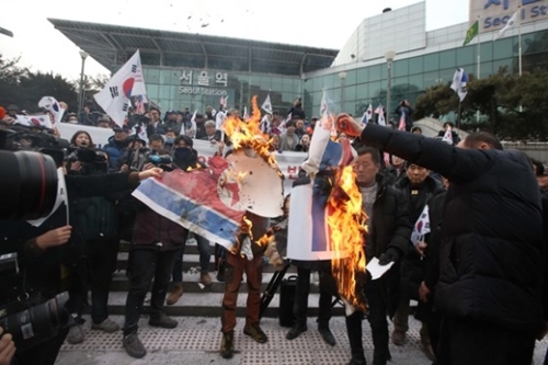 保守団体のメンバーが２２日、ソウル駅で北朝鮮国旗の火刑式を行っている。