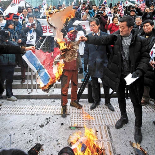 保守団体会員らがソウル駅前広場で北朝鮮の国旗を燃やしている。