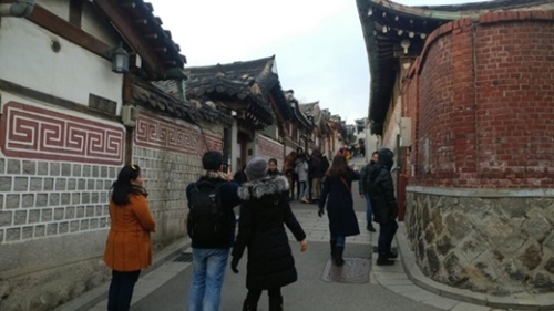 ６日、外国人観光客がソウル北村韓屋村を見回している。