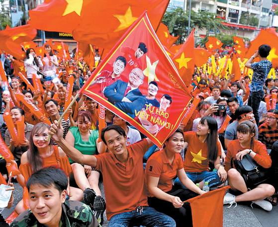 ２７日にベトナム・ホーチミン市の広場で市民が朴恒緒監督が描かれた旗を掲げて応援している。