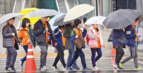 雨が降った１５日、傘を差した子どもたちがソウル清渓広場付近を歩いている。