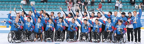 日本・チェコなどに勝って銅メダルを獲得した韓国障害者アイスホッケー代表が１８日、表彰式でポーズを取っている。金メダル１個、銅メダル２個で総合１６位になった韓国選手団を含む４９カ国・５７０人の参加選手は絶望を克服して希望のストーリーを刻んだという評価を受けた。