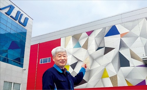 亜州スチールのイ・ハクヨン代表が慶尚北道亀尾市の本社でカラー鋼板を利用して施工した工場の建物について説明している。