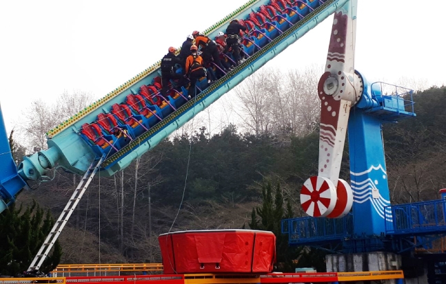 ２４日午後、光州市北区の中外公園で遊具が停止し、３～４メートルの高さで４５度に傾いた姿勢の利用客を救助隊員が救助している。（写真＝光州北部消防署）