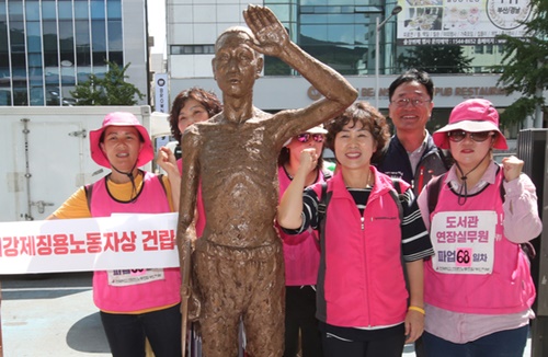 ２４日、釜山の日本総領事館前で市民団体が強制徴用労働者像設置パフォーマンスを行った。
