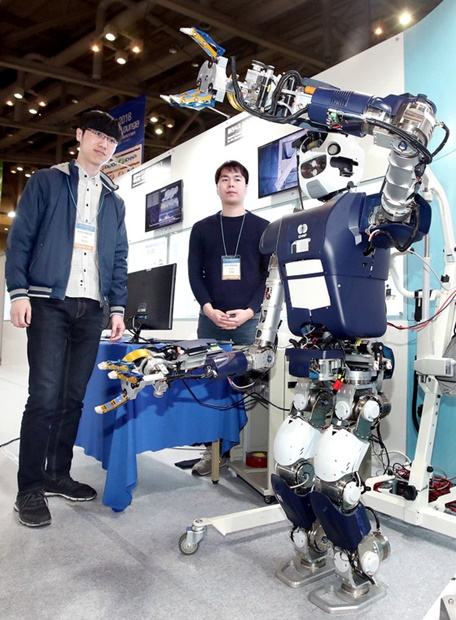 ２５日、釜山ＢＥＸＣＯで開かれている「２０１８釜山国際原子力産業展」で、韓国水力原子力ブースを訪れた観覧客が遠隔制御ロボットを見学している。
