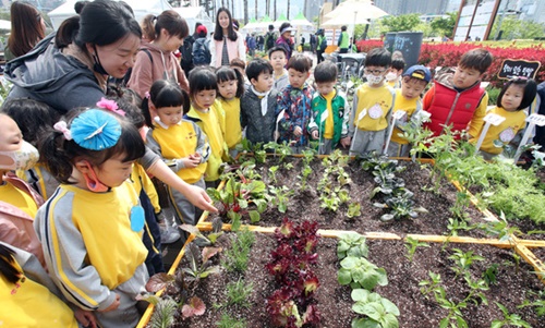 ２６日、釜山鎮区市民公園で開幕した第１４回釜山都市農業博覧会で、幼稚園児がサラダ用野菜などを栽培できる機能性菜園を見学している。
