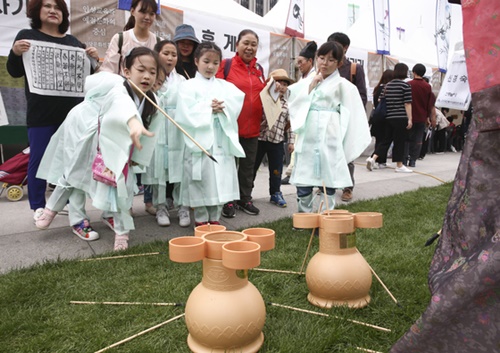 儒者の服装をした子どもたちが１３日午後、ソウル光化門（クァンファムン）広場で開かれた「大韓民国書堂文化ハンマダン大会」で、壷の中に矢を投げ入れる「投壺（トゥホ）」という遊びをしている。
