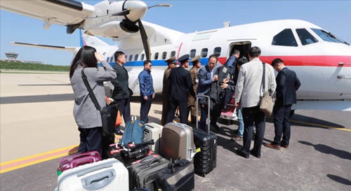 豊渓里核実験場廃棄南側共同取材団が２３日、政府輸送機便で元山葛麻飛行場に到着し、飛行機から降りている。