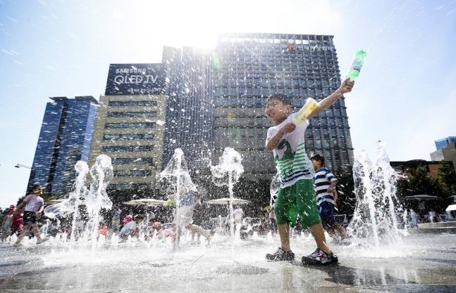 週末の２日午後、ソウル・光化門広場の噴水で子どもたちが水遊びをしている。