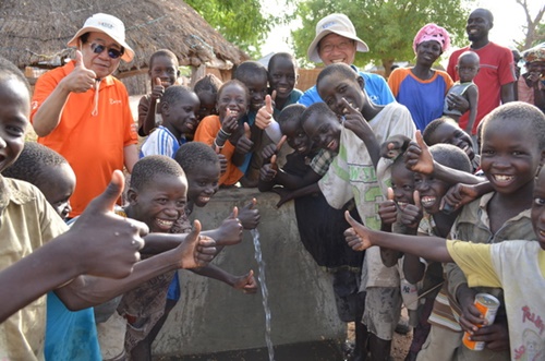 ２０１３年６月、セネガルでＫＯＩＣＡ海外奉仕団員と住民らが飲用水開発事業で作られた飲料水台できれいな水が出てくるのを喜んでいる。（写真＝ＫＯＩＣＡ提供）