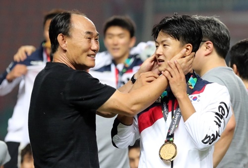 ２０１８ジャカルタ・パレンバン・アジア競技大会サッカー決勝の韓国－日本戦が１日、インドネシアのパカンサリスタジアムで行われた。表彰式の後、キム・ハクボム監督が李承佑（イ・スンウ）を顔をなでている。